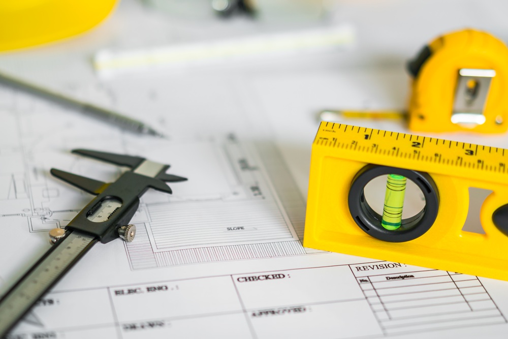 Construction plans with helmet and drawing tools on blueprints